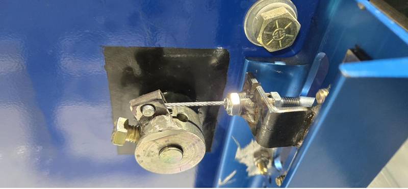 Cable tension bracket hardware mounted on a winch frame