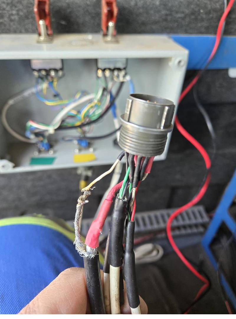 Multi-pin connector being hand-terminated with soldered and heat-shrunk leads