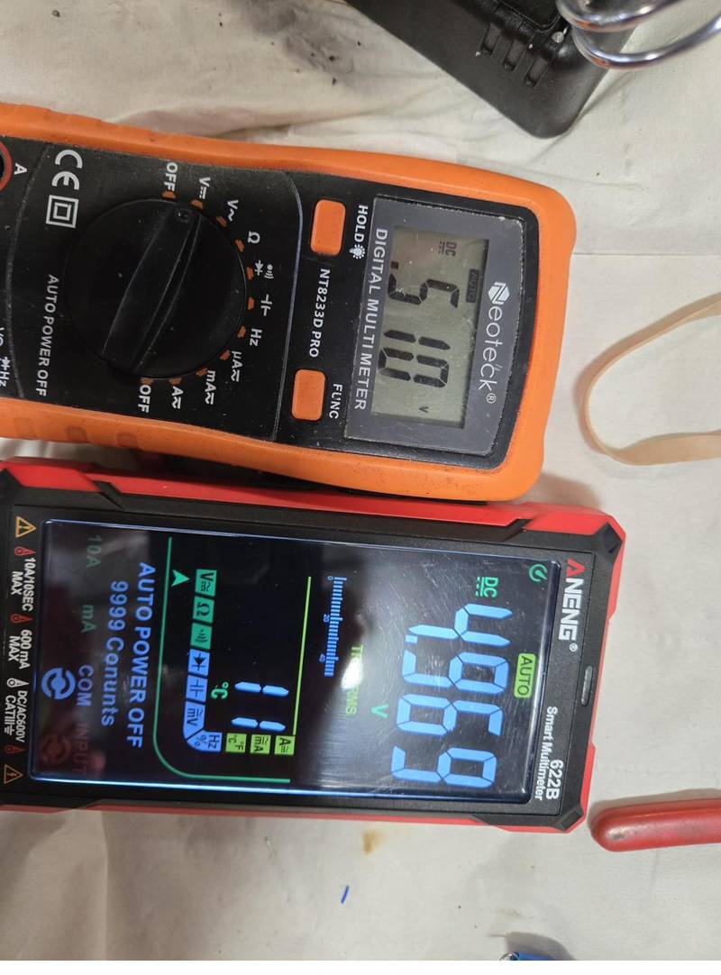 Two multimeters checking voltage on a finished panel